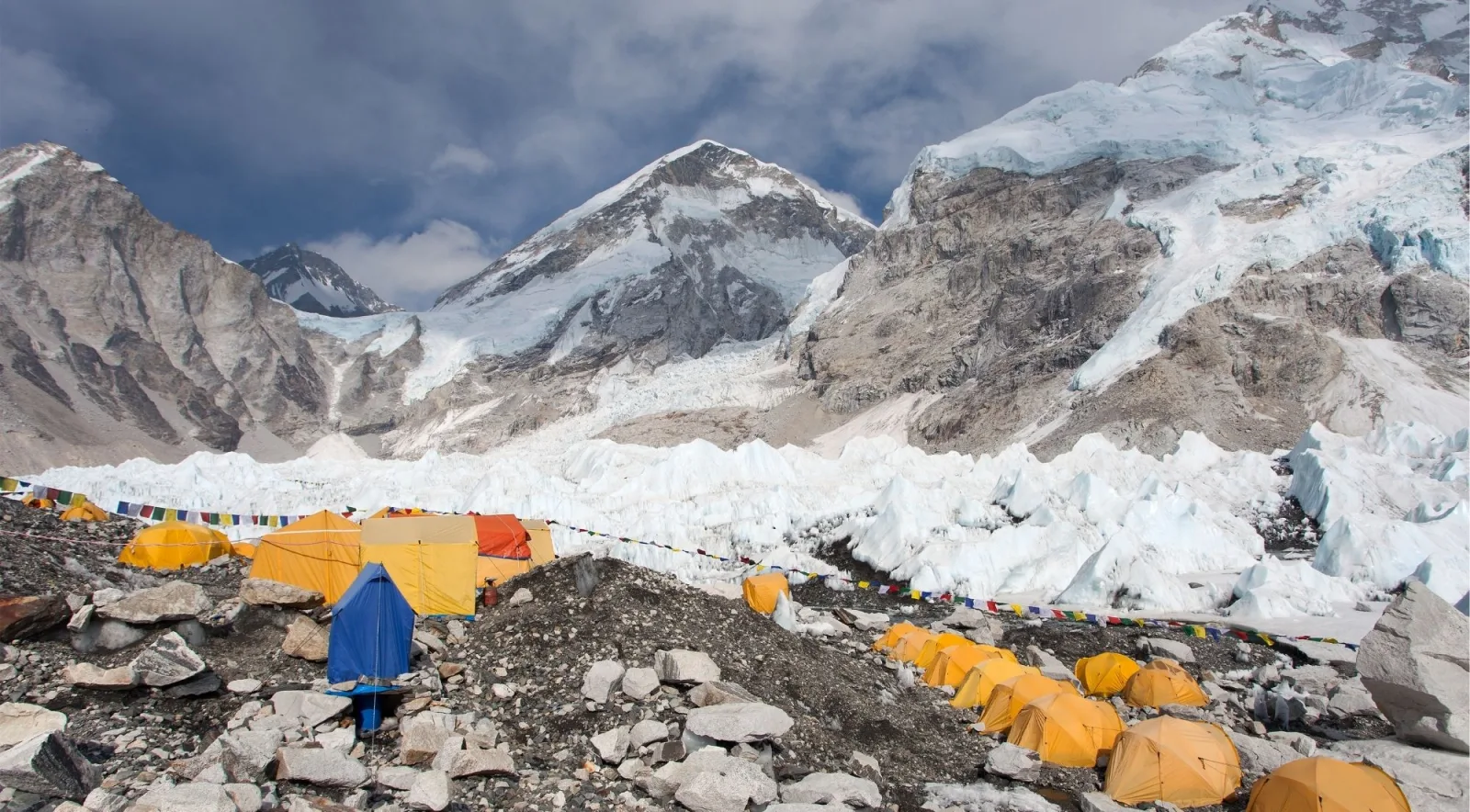 Everest's summit rising behind the Khumbu Icefall, with yellow tents at Base Camp