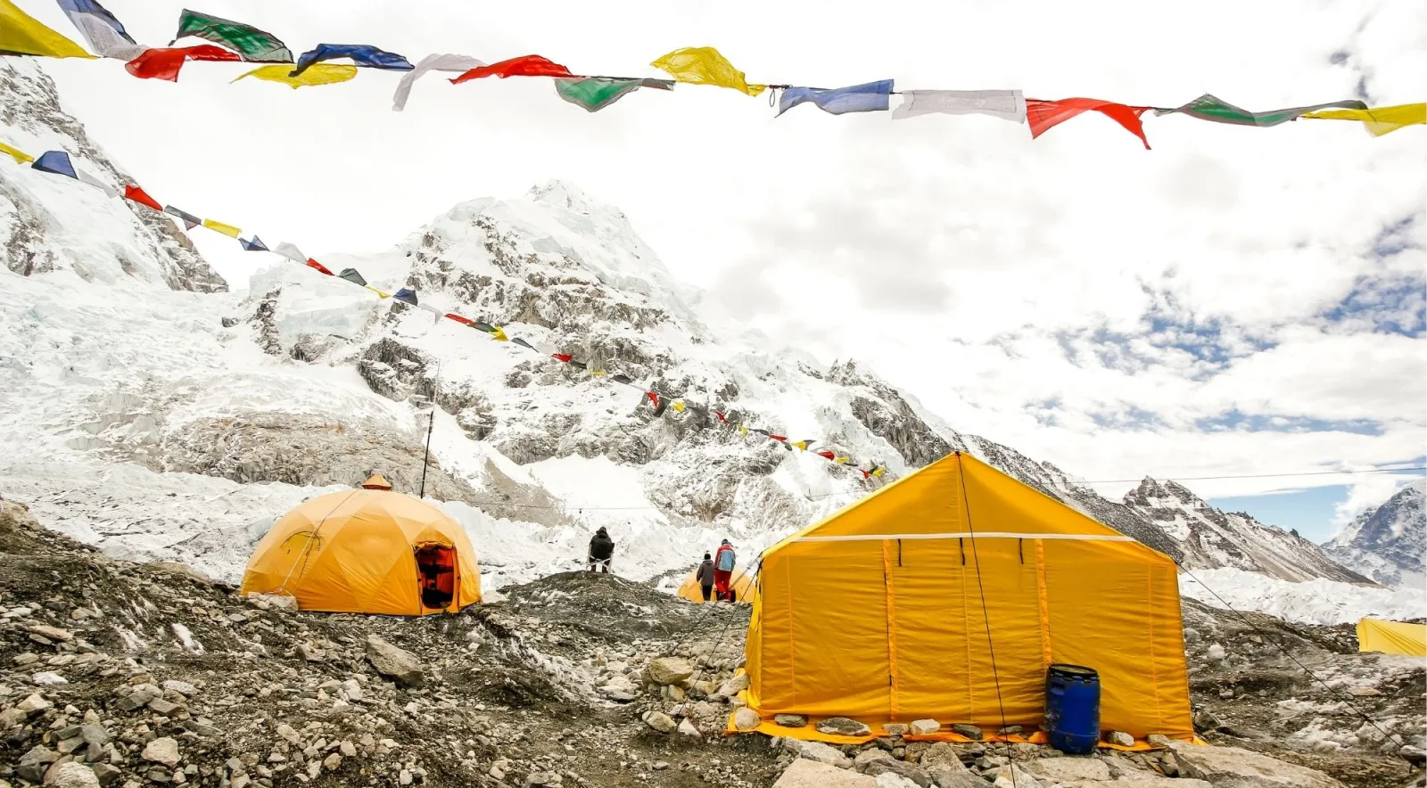 Prayer flags strung between tents at Everest Base Camp with the Khumbu Icefall behind